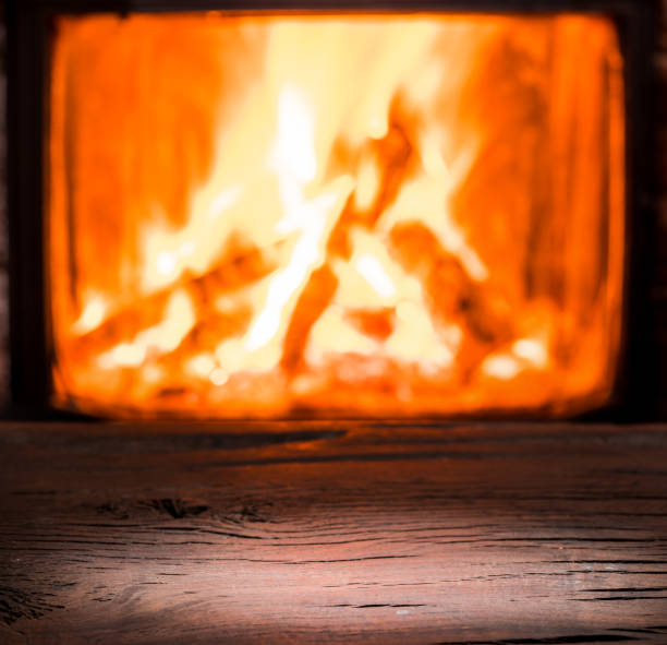 istock Wooden table top and burning warm fire. 898995140