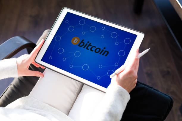 istock Woman holding a tablet with cryptocurrency logos 898995230