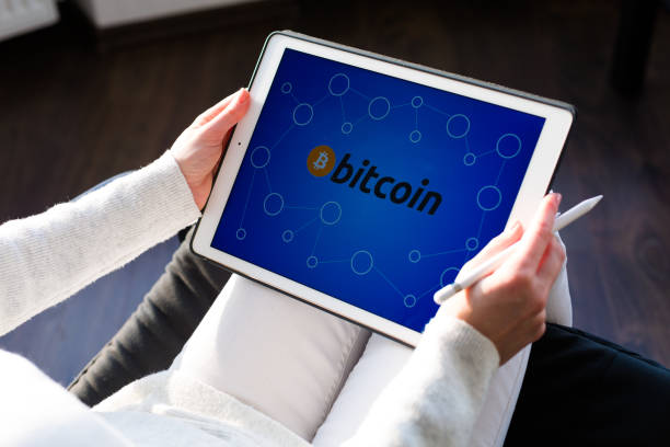 istock Woman holding a tablet with cryptocurrency logos 898995374
