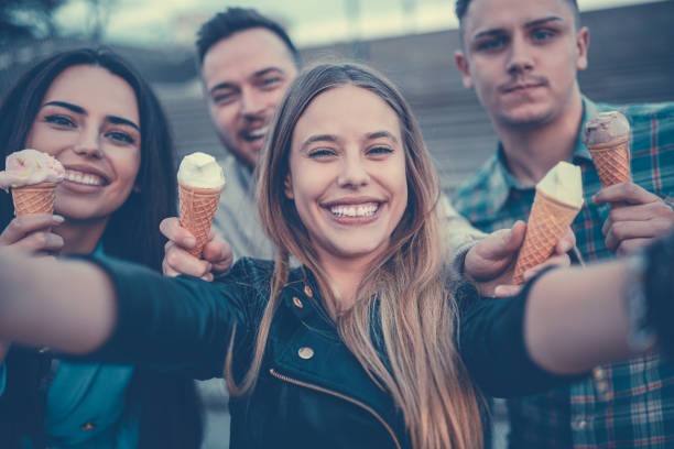 istock Smiling Friends Holding Cones with Ice Cream and Taking Selfie 899002036
