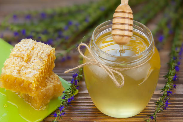 istock Delicious delicious honey in  jar on table 899004292