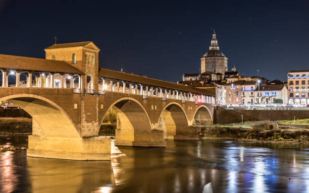 Night view of Pavia with Ponte Coperto and the river Ticino stock photo