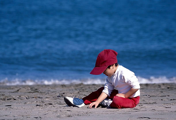 istock Young Kid Sitting and Playing on Beach 89900866