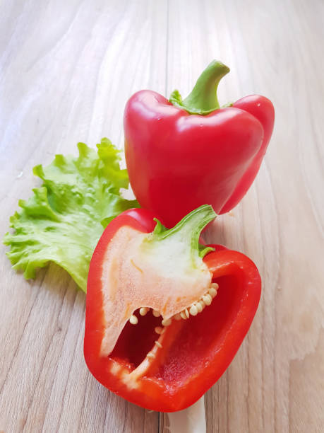 istock Fresh red bell pepper (capsicum) and a cut one on a table background. 899010224