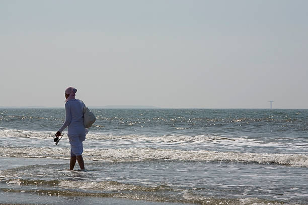 istock muslim woman walking along the coast 89901405