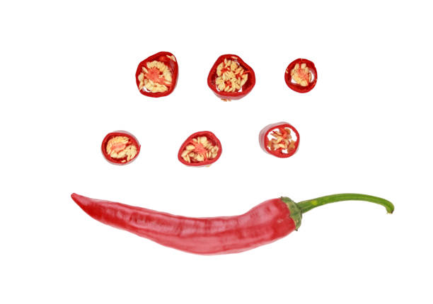 one red hot chilli pepper and six slices of pepper with seeds isolated on white background