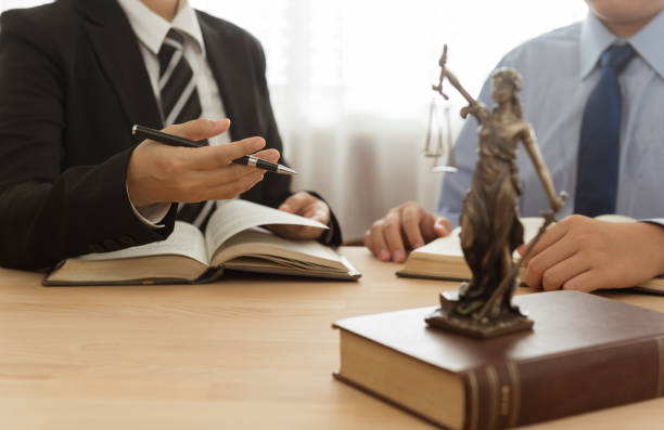 lawyer and client Law, Legal advice, Legislation concept. Lady justice on law book with lawyer and client in law office. judgement photos stock pictures, royalty-free photos & images