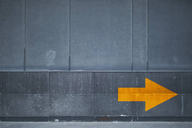 istock Direction - Yellow arrow sign on wall 899024608