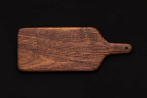 istock Walnut handmade wooden cutting board on black cotton 899028886