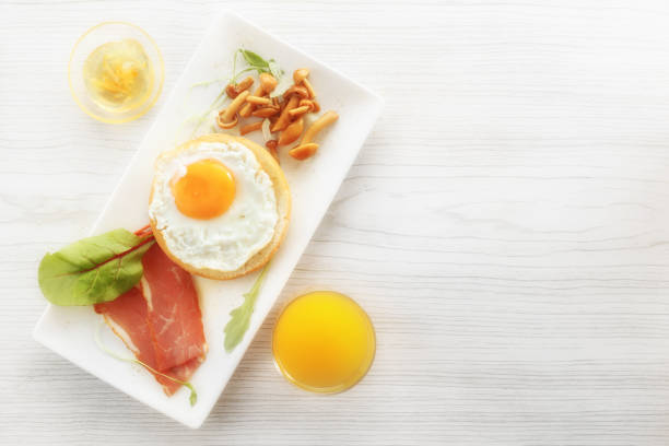istock Breakfast with fried egg on bread, bacon, mushrooms, greens. Sauce and fresh juice 899031394