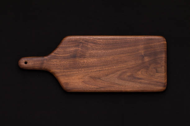 istock Walnut handmade wooden cutting board on black cotton 899032268