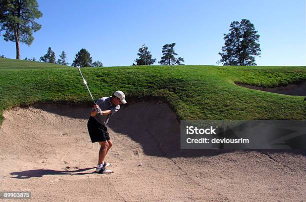 Golfer Successfully Hitting Golf Ball Out Of A Sand Trap Stock Photo - Download Image Now