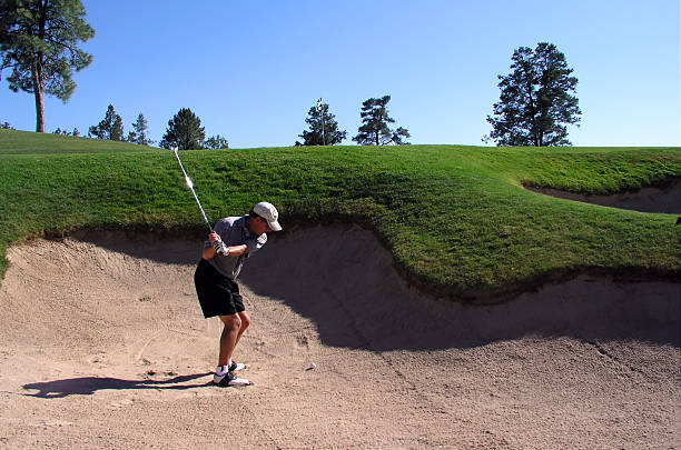 пакет услуг «golfer успешно ударяя мяч для гольфа из песчаная ловушка - golf course usa scenics sports flag стоковые фото и изображения