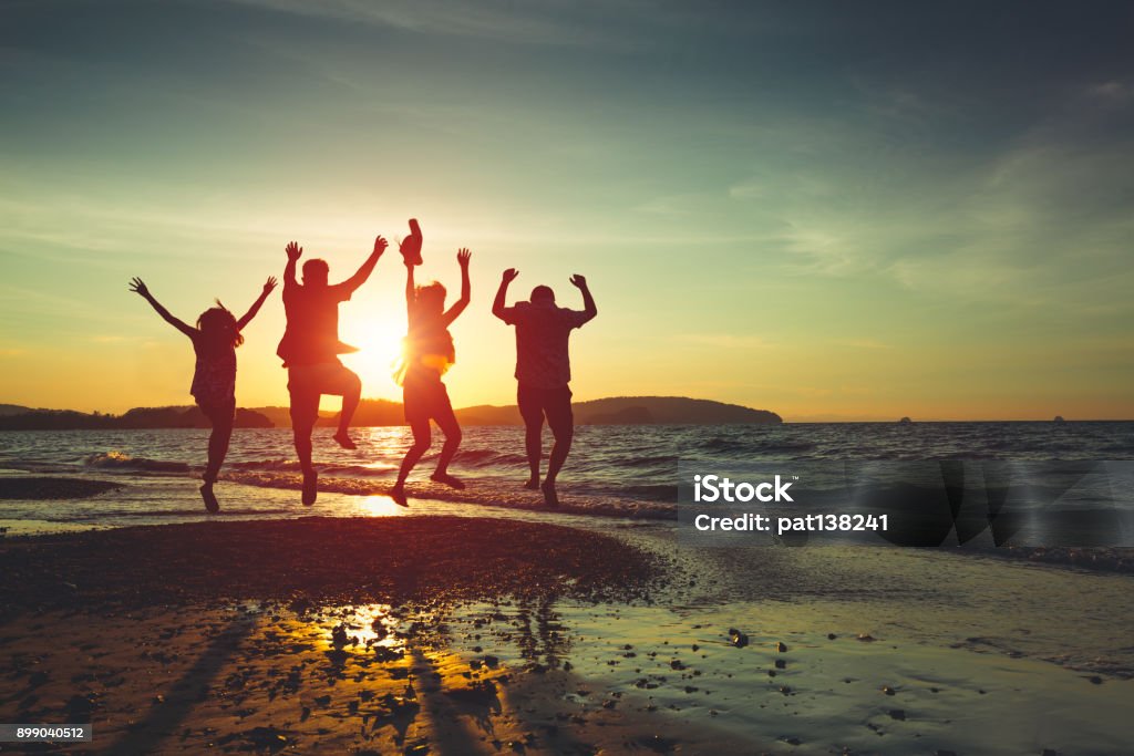 Spring break Asian family running on background of sunset beach and sea Beach Stock Photo