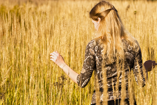 Young woman walking in a field.