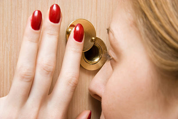 Woman looking into spy hole closeup  peep hole stock pictures, royalty-free photos & images