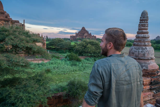 istock Young man contemplating the Bagan archeological zone at sunrise, Burma 899046750