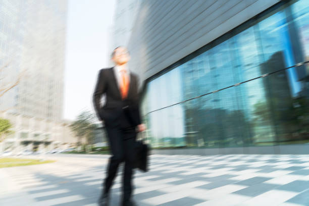 istock young businessman holding briefcase walking in city 899047620