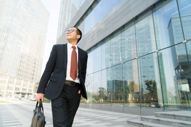 istock young businessman holding briefcase walking in city 899047644
