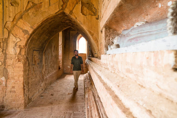 istock Young man contemplating inside ancient buddhist temple, Myanmar 899048076