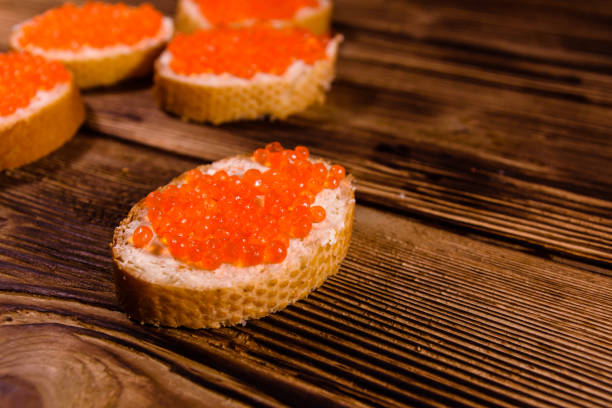 istock Sandwiches with red caviar on wooden table 899048348