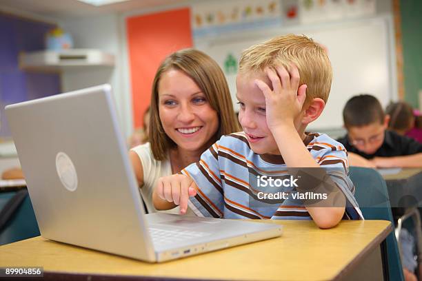 Elementary School Student And Teacher Look At Computer Stock Photo - Download Image Now