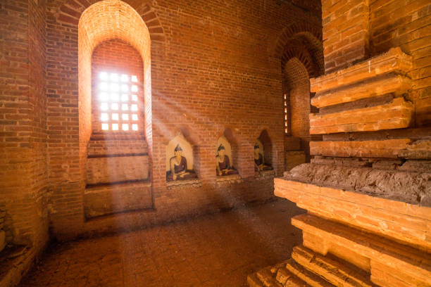 View of Bagan archeological zone from inside ancient temple, buddha statue. Bagan counts more than 2200 temples and stupas in the present day.