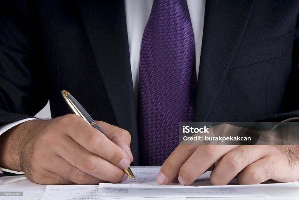 Uomo d'affari firma documenti sulla scrivania, primo piano - Foto stock royalty-free di Abbigliamento da lavoro