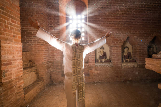 Caucasian young woman arms outstretched inside the Bagan ancient temple. People travel concept.