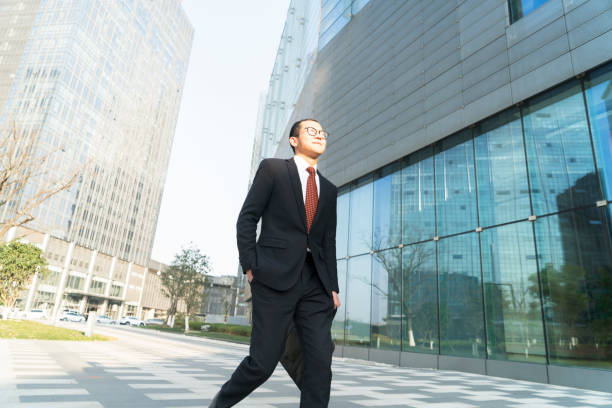istock young businessman holding briefcase walking in city 899059456