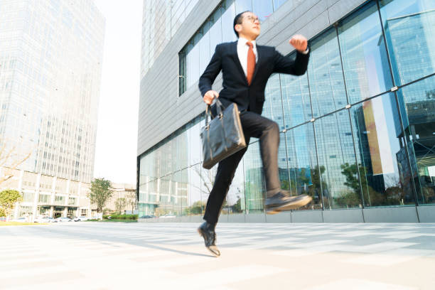 istock young businessman carrying briefcase running and jumping 899059676