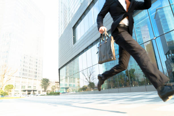 istock young businessman carrying briefcase running and jumping 899059690