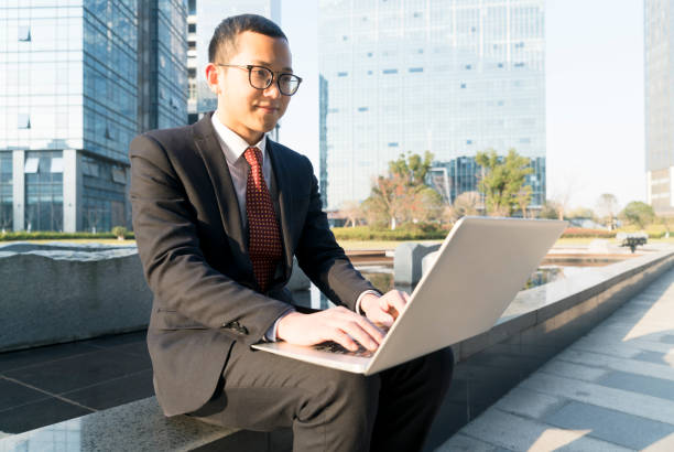 istock young businessman using laptop in city 899060022