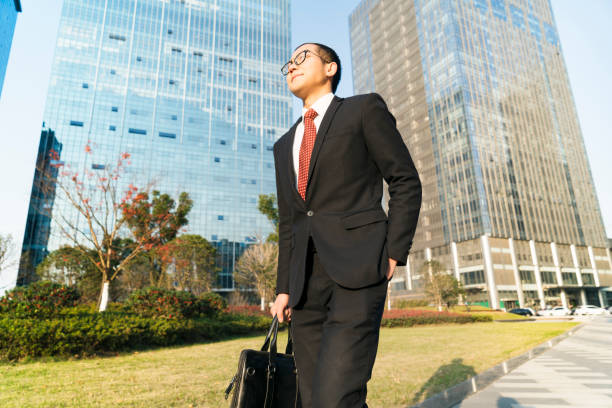 istock young businessman holding briefcase walking in city 899060368