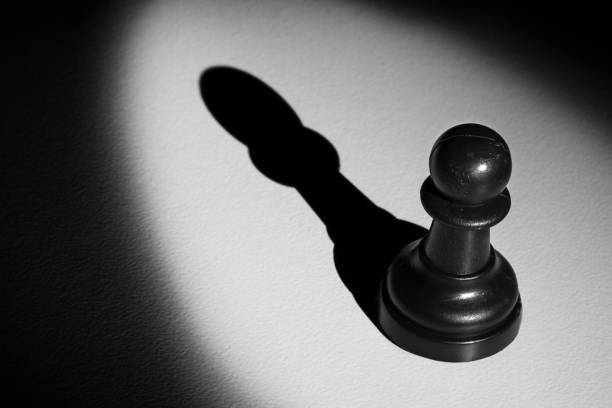 istock Chess pawn standing in a spotlight that make a shadow with darkness 899065448