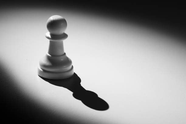 istock Chess pawn standing in a spotlight that make a shadow with darkness 899065454