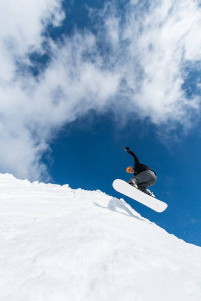 istock Snowboarder jumping against blue sky 899065914