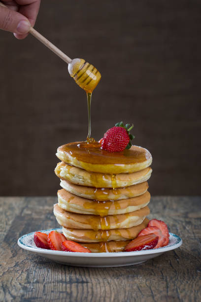 istock Stack of pancakes with strawberries and honey dripping over it 899068248