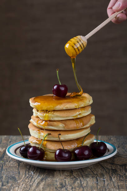 istock Stack of pancakes with berries and honey dripping over 899068562