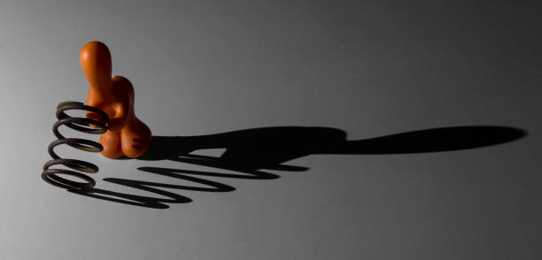 istock Shadow of a toy man holding a metal spring in a spotlight 899069190
