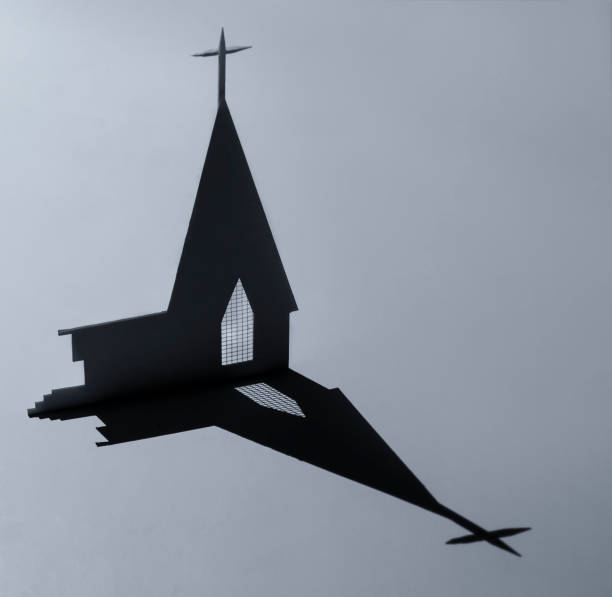 Paper church with shadow from a spotlight in a studio on grey background