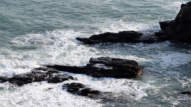 istock The waves knocked against the rocks. 899070094