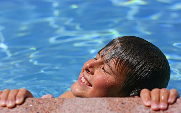 young boy disfruta del sol en la piscina - historical reenactment fun heat recreational pursuit fotografías e imágenes de stock