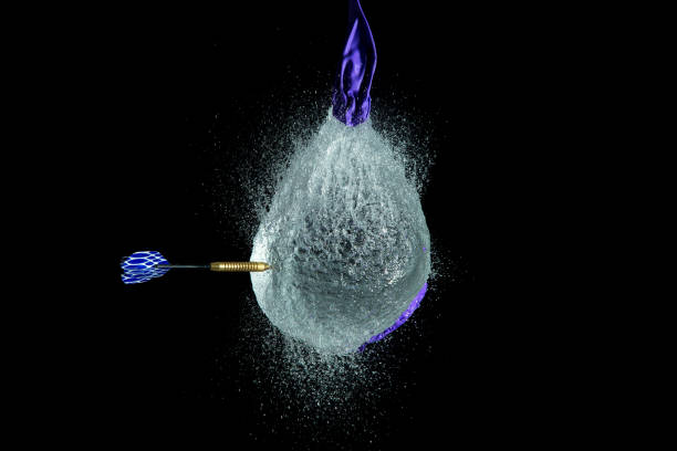 balloon filled with water is popped with a dart to make a mess - rubber dart imagens e fotografias de stock