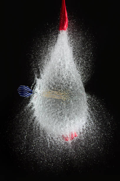 balloon filled with water is popped with a dart to make a mess - rubber dart imagens e fotografias de stock