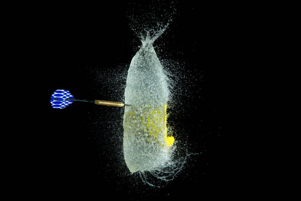 balloon filled with water is popped with a dart to make a mess - rubber dart imagens e fotografias de stock