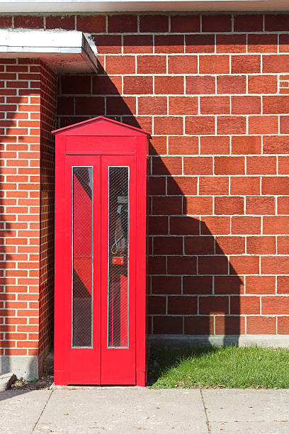 cabine de téléphone rouge et mur de briques - pay phone brick wall telephone old photos et images de collection