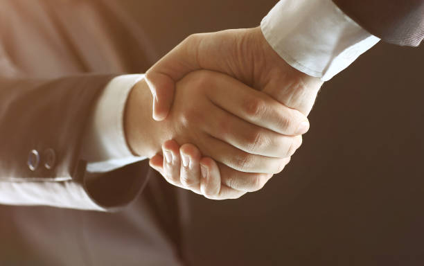 istock Handshake - Hand holding in the black background 899086078