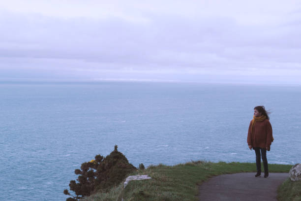 istock Lonely girl on cliffs above the sea 899091632