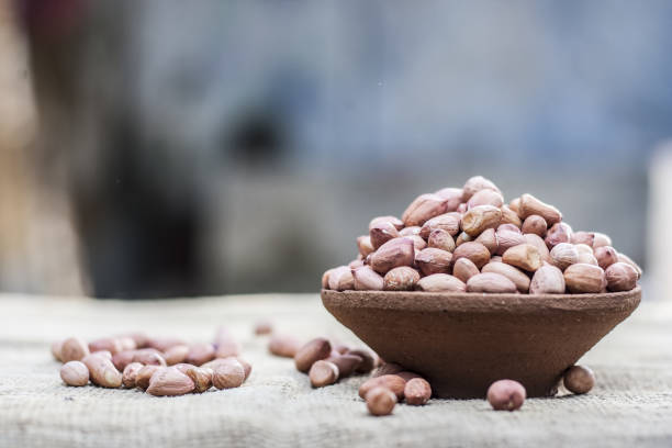 istock Arachis hypogaea, Raw fresh peanuts in a clay bowl on gunny background 899091654